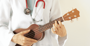 Pessoa de jaleco branco tocando um ukulele