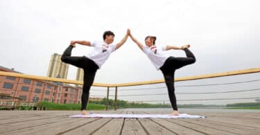 Duas pessoas fazendo Yoga em dupla.