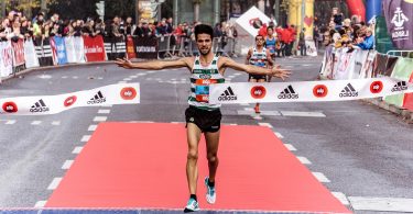 Homem finalizando uma corrida como vencedor.