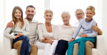 Família reunida num sofá. Avós, filha ou filho, nora ou genro e netos.