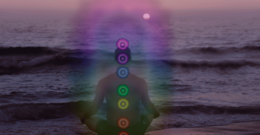 Pessoa na praia meditando, ilustrando a energia dos chakras