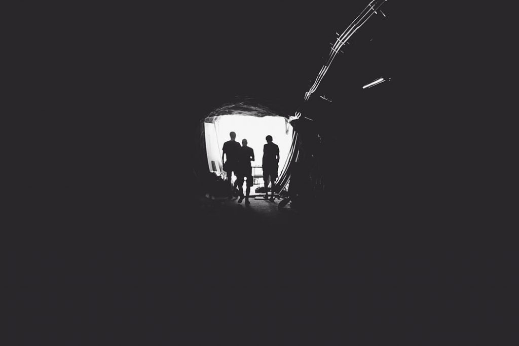 Três pessoas no fim de um túnel.
