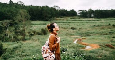 Mulher em paisagem com natureza olhando para cima.