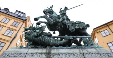 Estátua gigante de São Jorge em um cavalo, segurando sua espada, com um dragão morto embaixo.