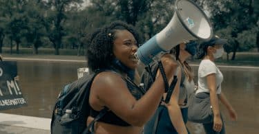 Mulher falando em um megafone em protesto