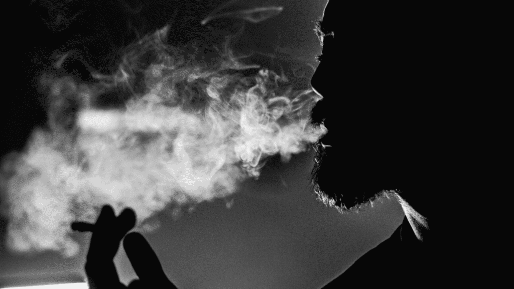 Foto em preto e branco de homem fumando