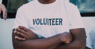 Homem negro usando camiseta escrito "volunteer".