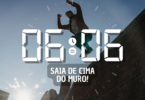 Hora igual 06:06 e texto "Saia de cima do muro!" aplicado por cima de foto de um homem pulando um muro de tijolos. Ao fundo, há um céu azul e a luz do sol.