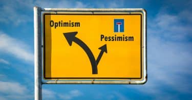 Uma placa com os seguintes elementos gráfico-visuais: 'pessimism' à esquerda, com uma seta à esquerda; com uma seta à direita, 'otimism'.