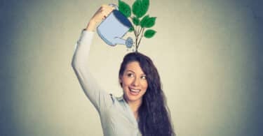 Mulher regando uma planta na cabeça dela