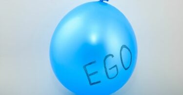 Imagem de fundo cinza e em destaque um balão azul e nele está escrito a palavra EGO.