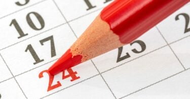 Calendário mensal e um lápis vermelho para marcar a data 24.