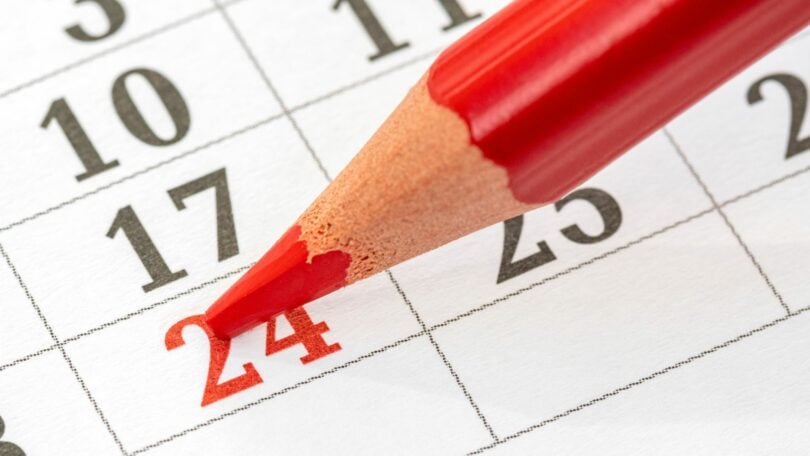 Calendário mensal e um lápis vermelho para marcar a data 24.