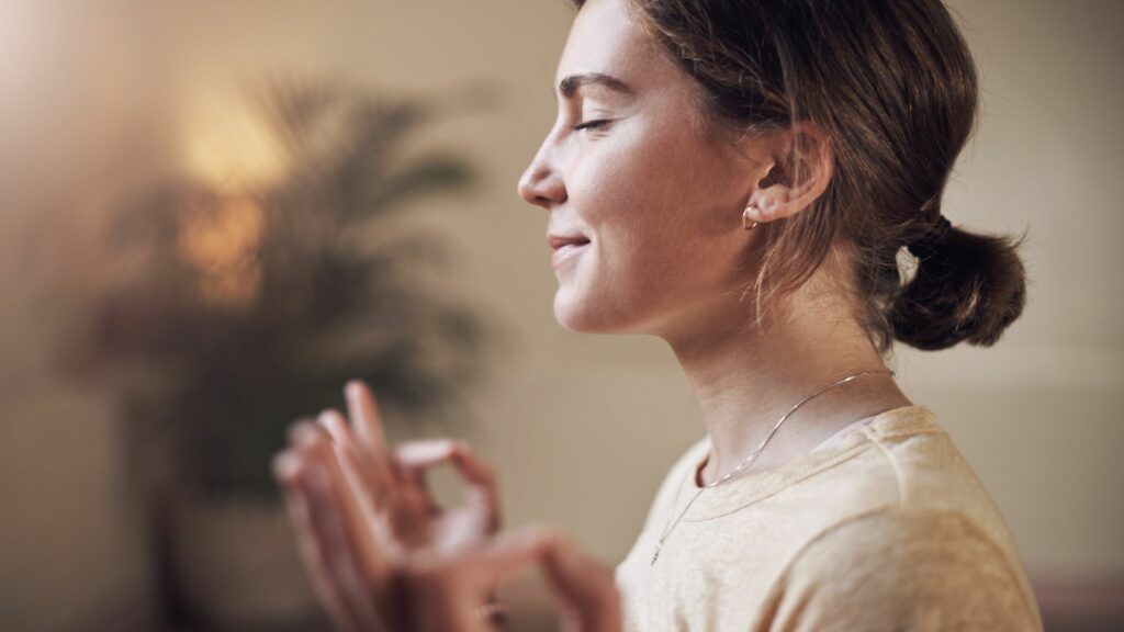 Imagem de uma mulher fazendo meditação, trazendo o conceito que meditar é treinar a paciência.
