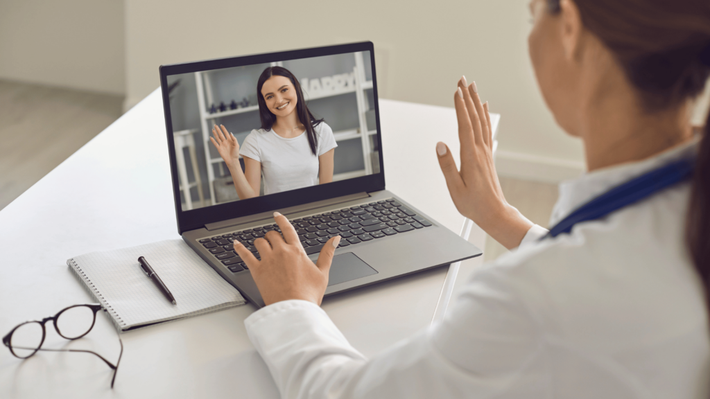 Paciente mulher cumprimentando sua médica on-line na tela do laptop . 