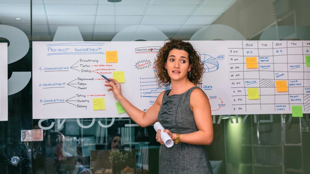 Imagem de uma treinadora feminina mostrando gerenciamento de projetos em um Programa de Coaching de Carreira.