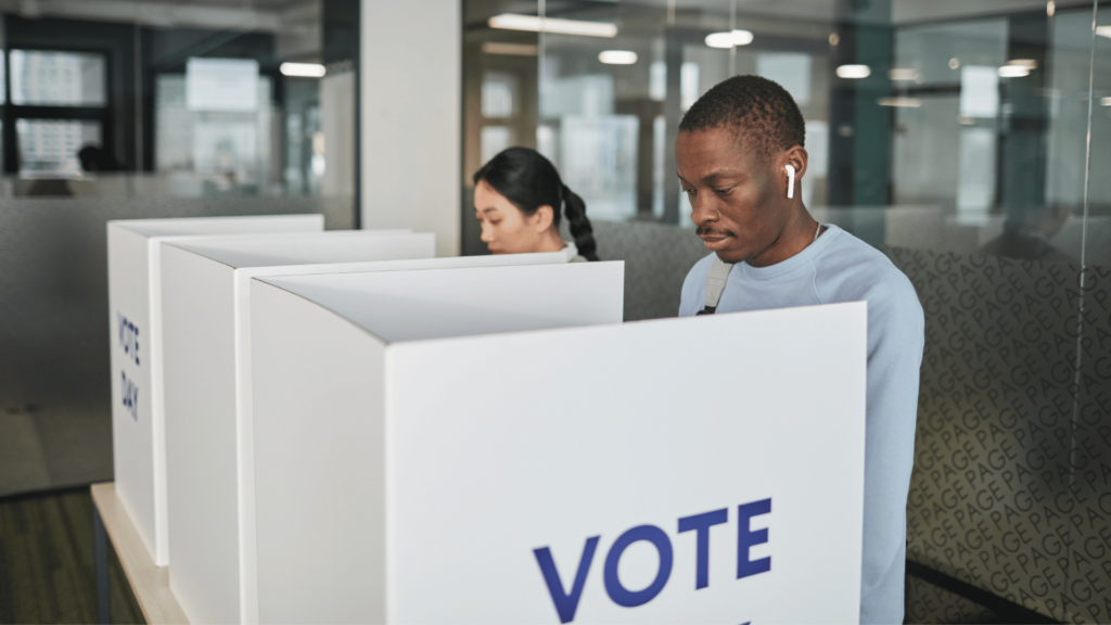 Pessoas em cabines eleitorais, votando. 