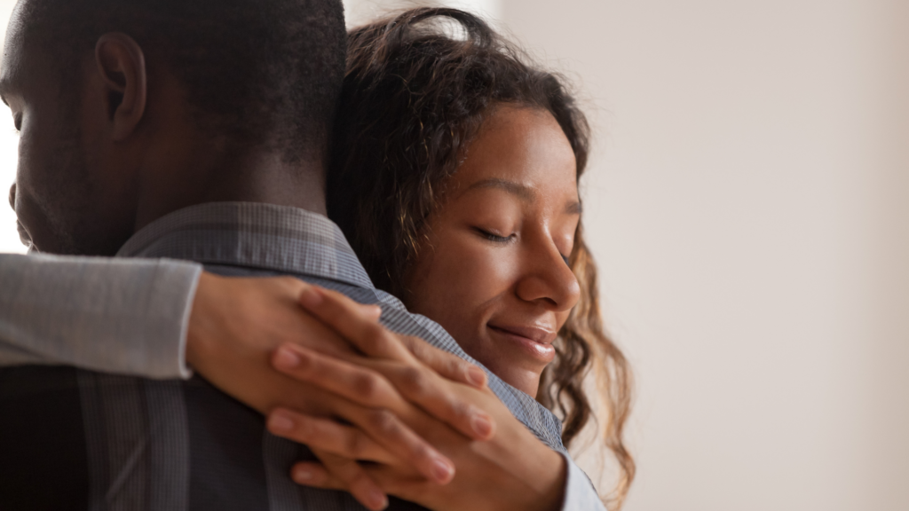 Imagem de um casal africano se abraçando, representando a saudade.