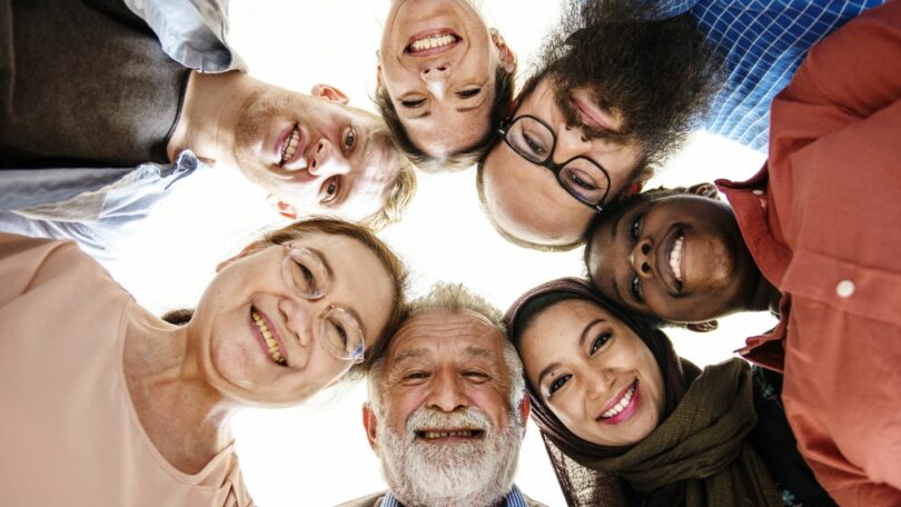 Imagem de diversas pessoas felizes e unidas, trazendo o conceito e humanismo e coletividade.