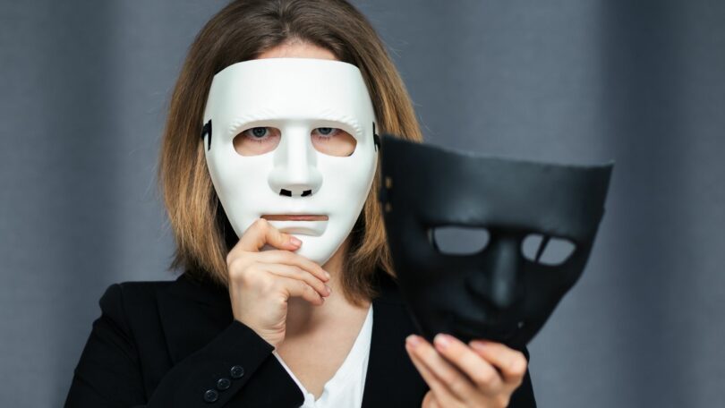 Imagem de uma mulher que experimenta diferentes personalidades na forma de máscaras, nas cores preto e branco, trazendo o conceito de transtorno de personalidade borderline.