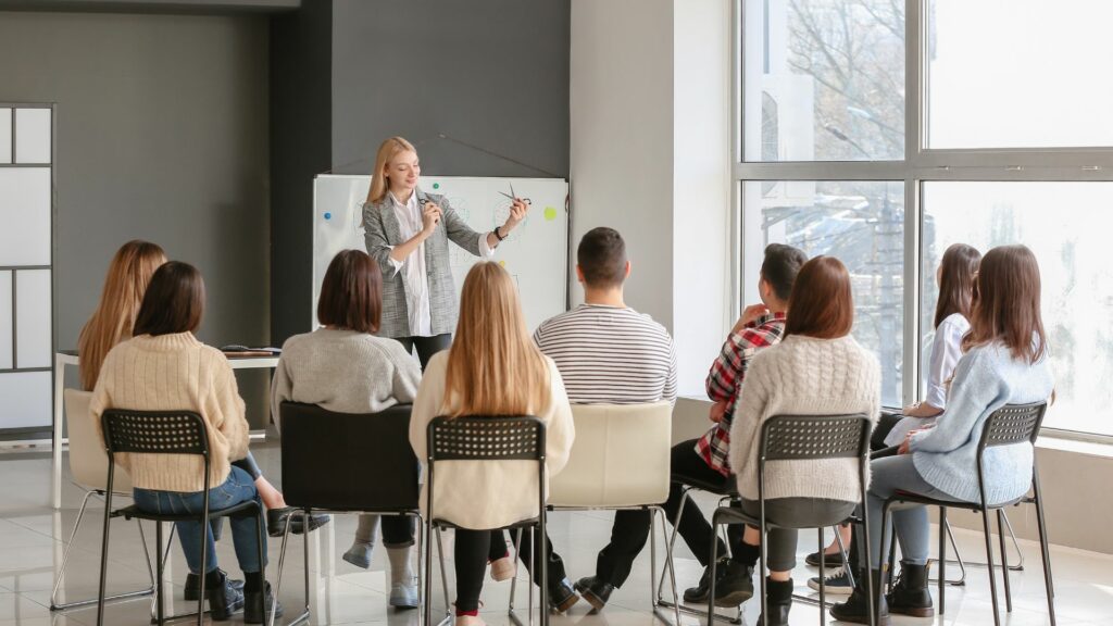 Imagem de um grupo de profissionais terapêuticos sentandos em uma sala fazendo um curso de especialização.